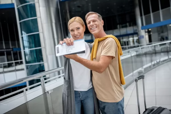 Cheerful middle-aged couple showing their travel documents